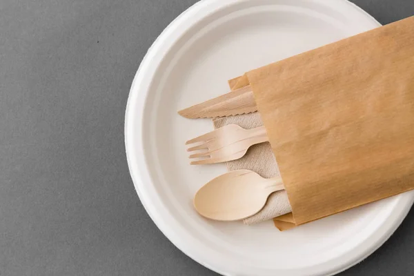 Cuchara de madera, tenedor y cuchillo en la placa de papel — Foto de Stock