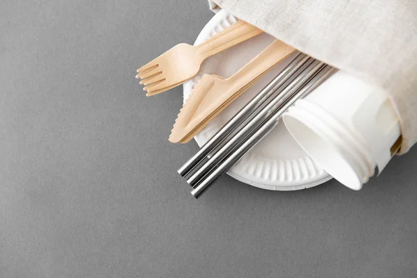 Wooden forks, knives and paper cups on plate — Stock Photo, Image