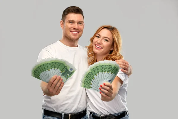 Glückliches Paar in weißen T-Shirts mit Eurogeld — Stockfoto