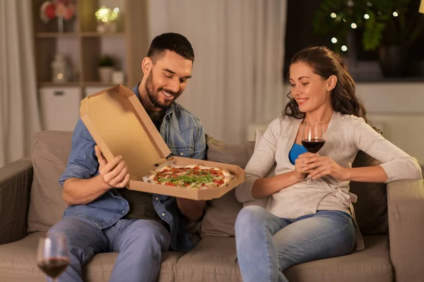 Щаслива пара їсть піцу на винос вдома — стокове фото