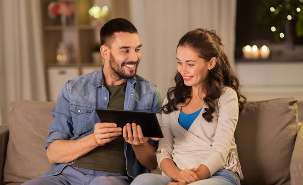 Couple heureux en utilisant tablette PC à la maison le soir — Photo