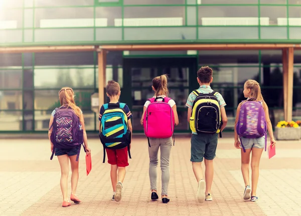 Gruppo di felici studenti delle scuole elementari a piedi — Foto Stock