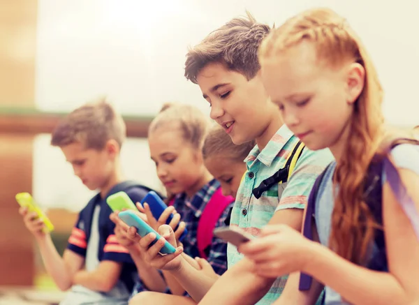 Elementary school students with smartphones — Stock Photo, Image