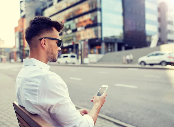 Närbild på mannen textning på smartphone i city — Stockfoto