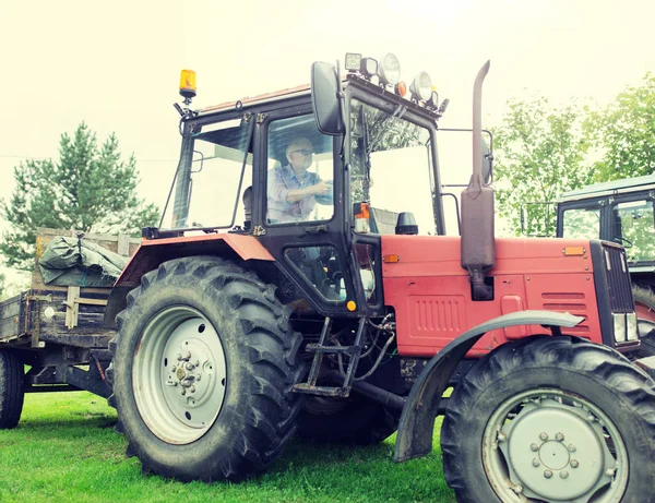 Senior fährt Traktor auf Bauernhof — Stockfoto
