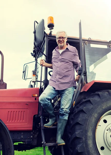 Alter Mann oder Landwirt steigt auf Bauernhof aus Traktor aus — Stockfoto