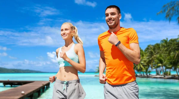 Sorridente coppia che corre lungo esotico sulla spiaggia — Foto Stock