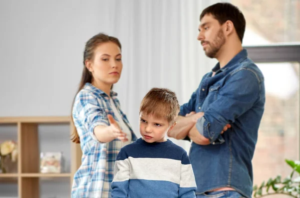 Несчастный маленький мальчик спорит с родителями дома — стоковое фото