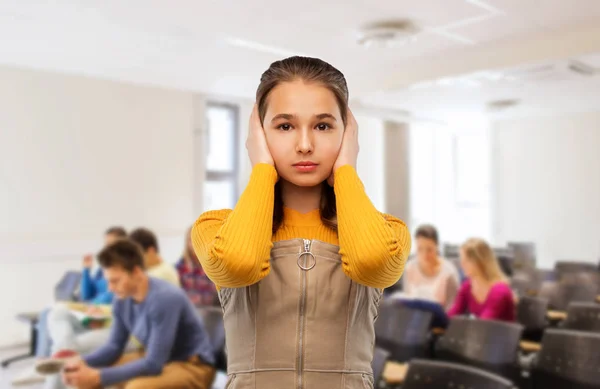 Student flicka stänga öron med händerna i skolan — Stockfoto