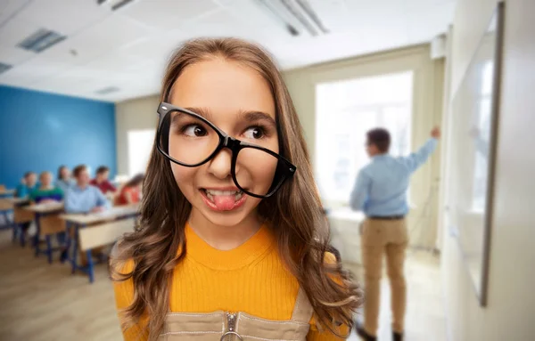 Usmívající se dospívající studentka v brýlích ve škole — Stock fotografie