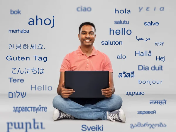 Homem indiano feliz com computador portátil no chão — Fotografia de Stock