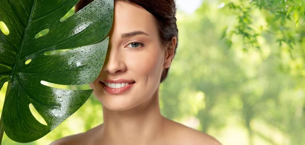 Hermosa joven con hoja de monstera verde —  Fotos de Stock