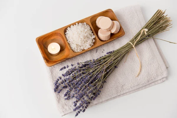 Sal marinho, sabão, vela e lavanda na toalha de banho — Fotografia de Stock