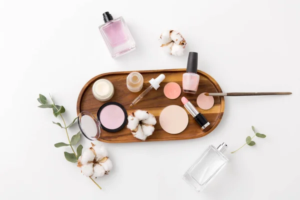 Makeup, perfume and cosmetics on wooden tray — Stock Photo, Image