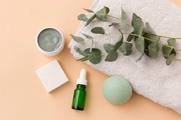 Sérum, masque d'argile, huile et eucalyptus sur serviette de bain — Photo