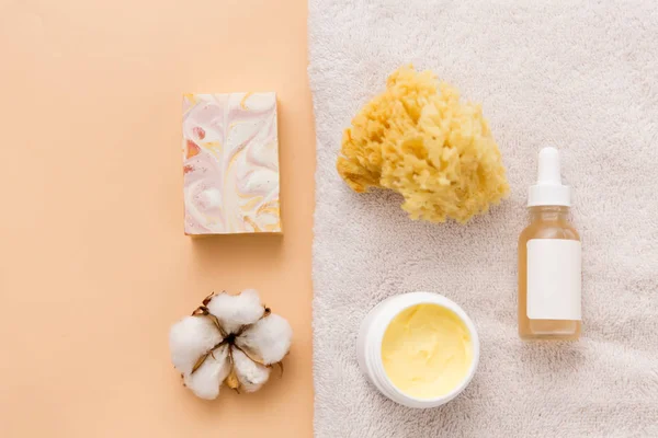 Body butter, essential oil, sponge on bath towel — Stock Photo, Image