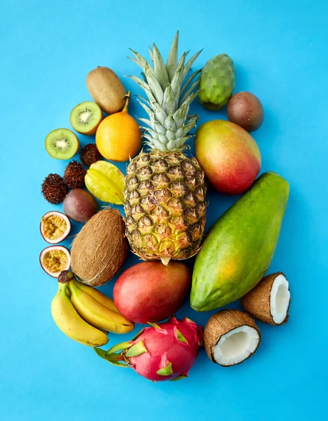 Sok különböző egzotikus gyümölcsök kék háttér — Stock Fotó