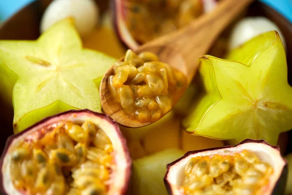 Close-up de frutas exóticas misturar com colher de madeira — Fotografia de Stock