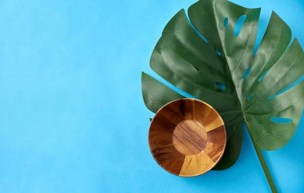 Wooden plate and monstera deliciosa leaf — Stok fotoğraf