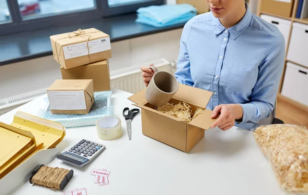 Femme emballage tasse à boîte de colis au bureau de poste — Photo