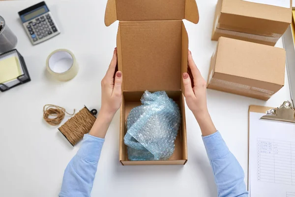 Hände packen Becher in Paketkasten bei Post — Stockfoto