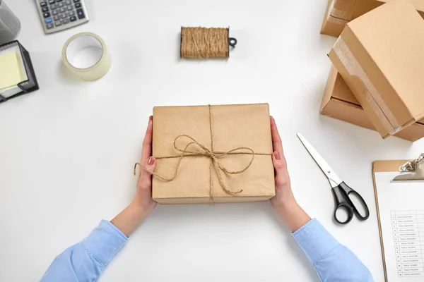 Mains avec boîte à colis attachées par corde au bureau de poste — Photo