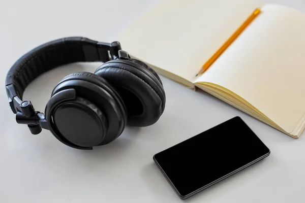 Headphones, smartphone and notebook with pencil — Stock Photo, Image