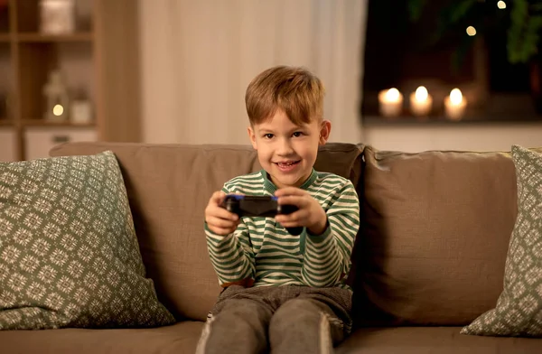 Kleiner Junge mit Gamepad spielt Videospiel zu Hause — Stockfoto