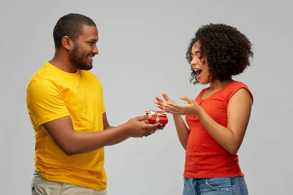 Feliz casal afro-americano com caixa de presente vermelho — Fotografia de Stock