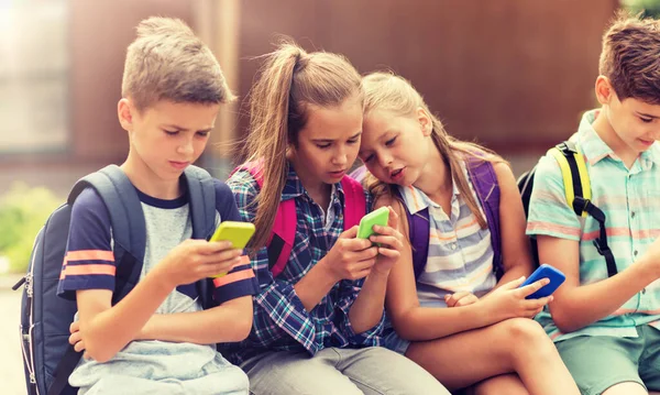 Uczniowie szkoły podstawowej ze smartfonami — Zdjęcie stockowe