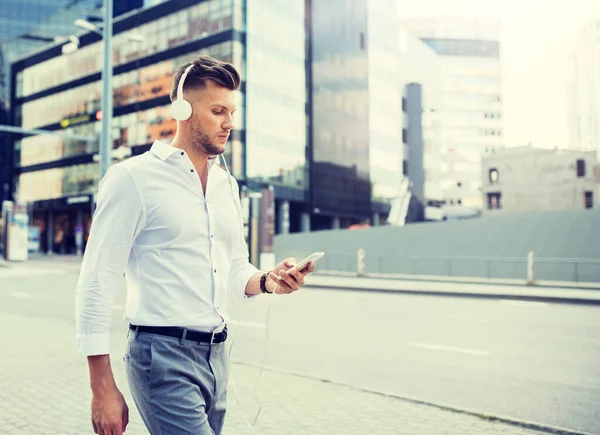 Adam akıllı telefon dinleme müzik ve kulaklık ile — Stok fotoğraf