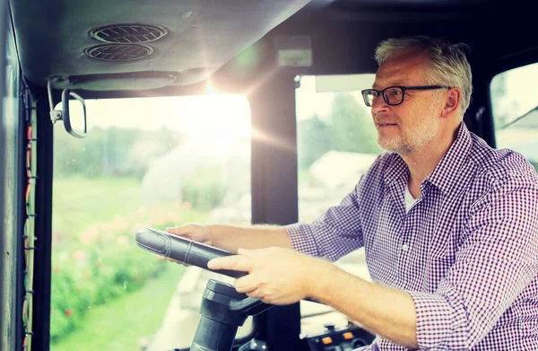 Senior man driving tractor at farm — Stock Photo, Image