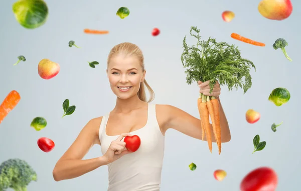 Glücklich lächelnde junge Frau mit Herz und Karotten — Stockfoto