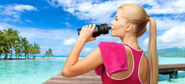 Happy smiling woman with sports bottle and towel — Stock Photo, Image