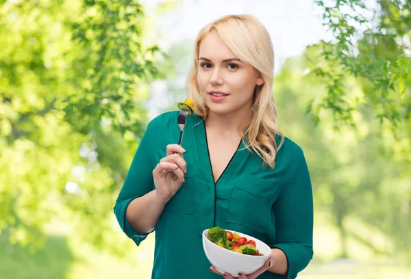 Sorridente giovane donna mangiare insalata di verdure — Foto Stock