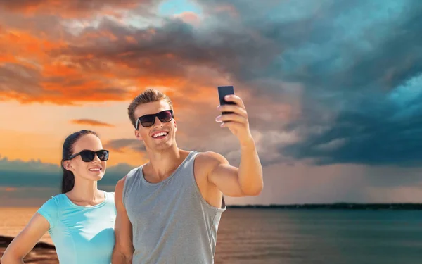 Para biorąc selfie przez smartfon na plaży — Zdjęcie stockowe