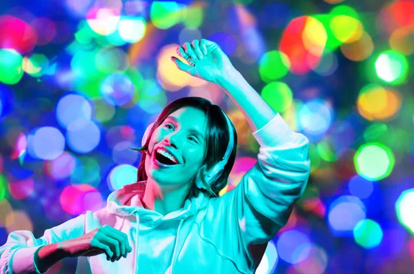 Mulher em fones de ouvido dançando sobre luzes da noite — Fotografia de Stock