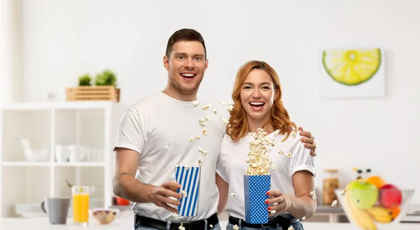 Glückliches Paar in weißen T-Shirts beim Popcorn essen — Stockfoto