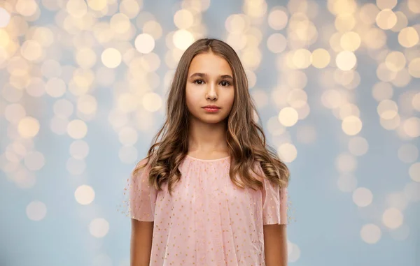 Teenage girl in party dress over festive lights — Stock Photo, Image