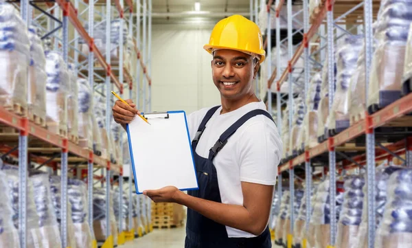 Happy indian worker with clipboard at warehouse — Stock Photo, Image