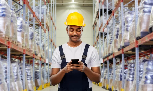 Loader of werknemer met smartphone in magazijn — Stockfoto