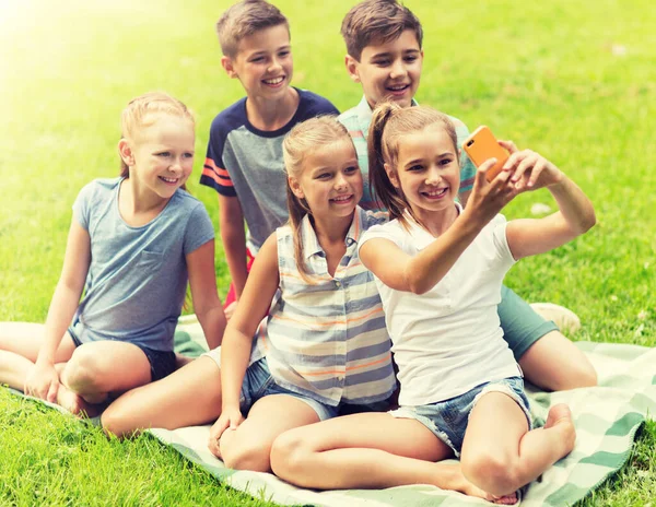 Šťastné děti nebo přátele s selfie v letním parku — Stock fotografie