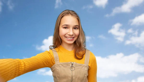 Счастливая девочка-подросток делает селфи в небе — стоковое фото