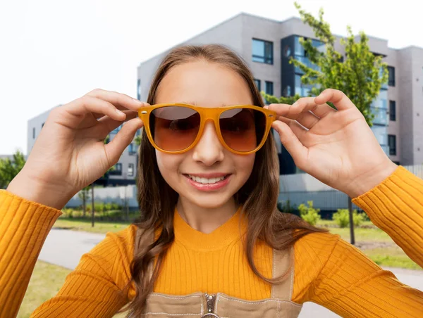 Lächelndes Teenager-Mädchen mit Sonnenbrille auf der Straße der Stadt — Stockfoto