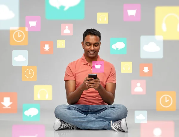 Felice uomo indiano utilizzando smartphone sopra icone app — Foto Stock