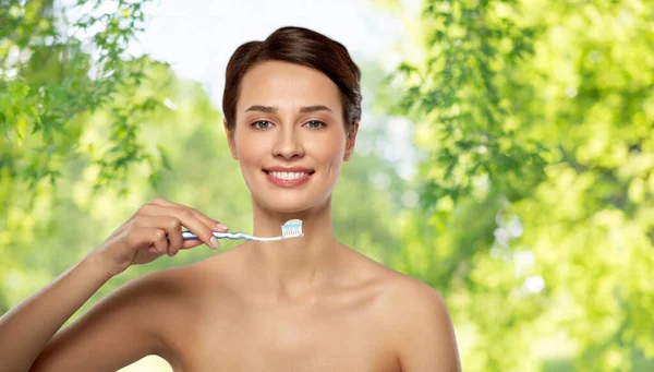 Glimlachende vrouw met tandenborstel schoonmaken tanden — Stockfoto