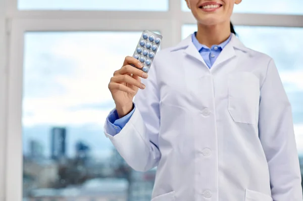 Smiling female doctor with pills at medical office — 스톡 사진