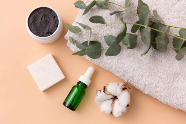 Sérum, masque d'argile, huile et eucalyptus sur serviette de bain — Photo