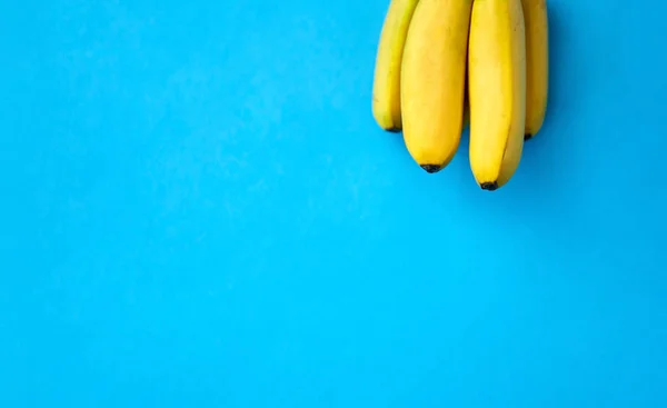 Primo piano di gruppo di banane mature su sfondo blu — Foto Stock