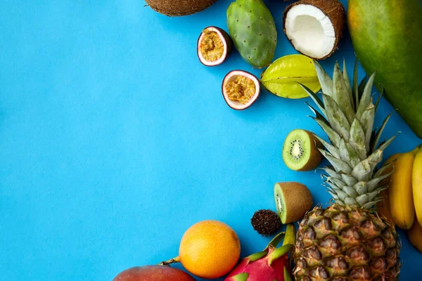 Verschiedene exotische Früchte auf blauem Hintergrund — Stockfoto